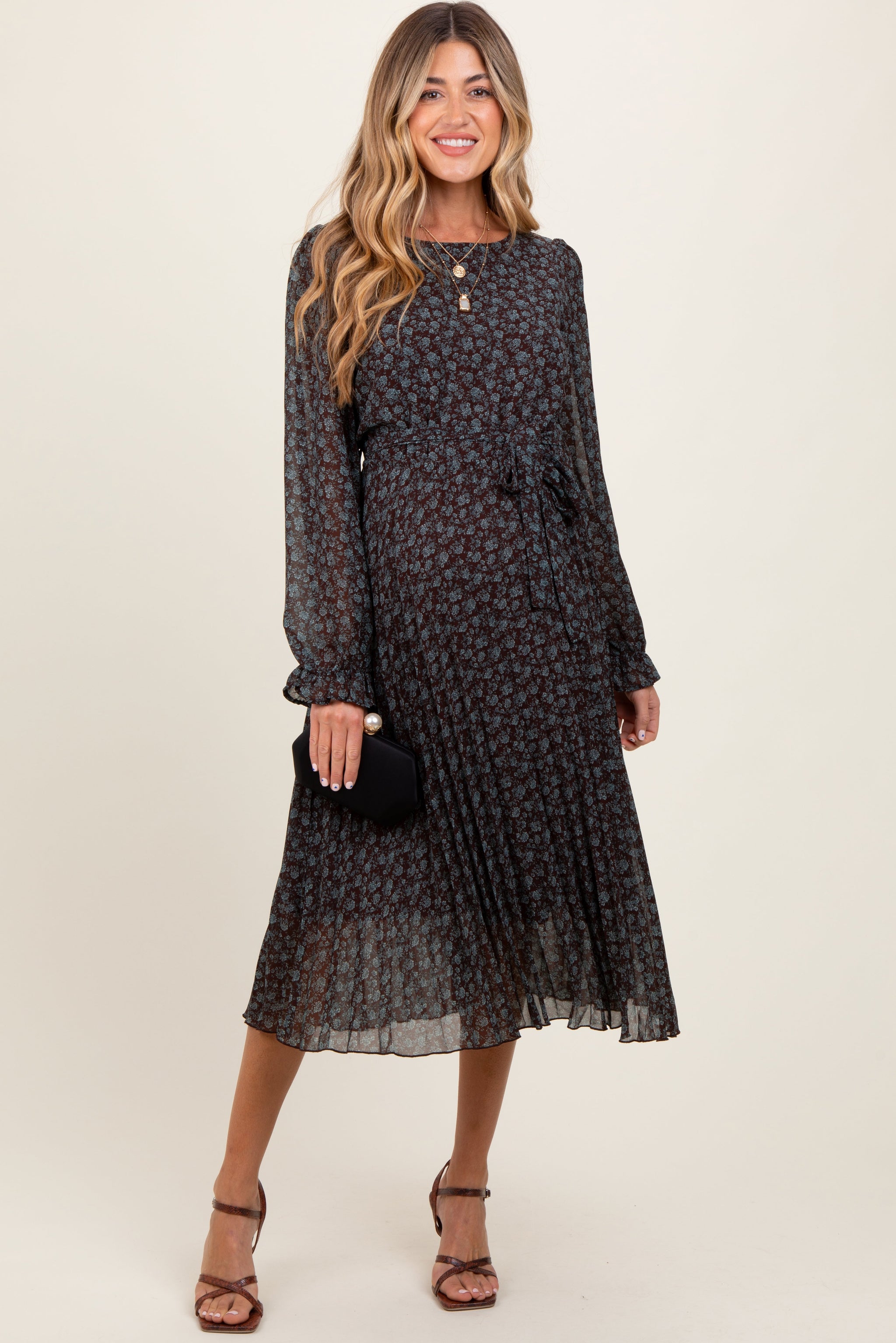 Woman wearing a black floral dress against a white background