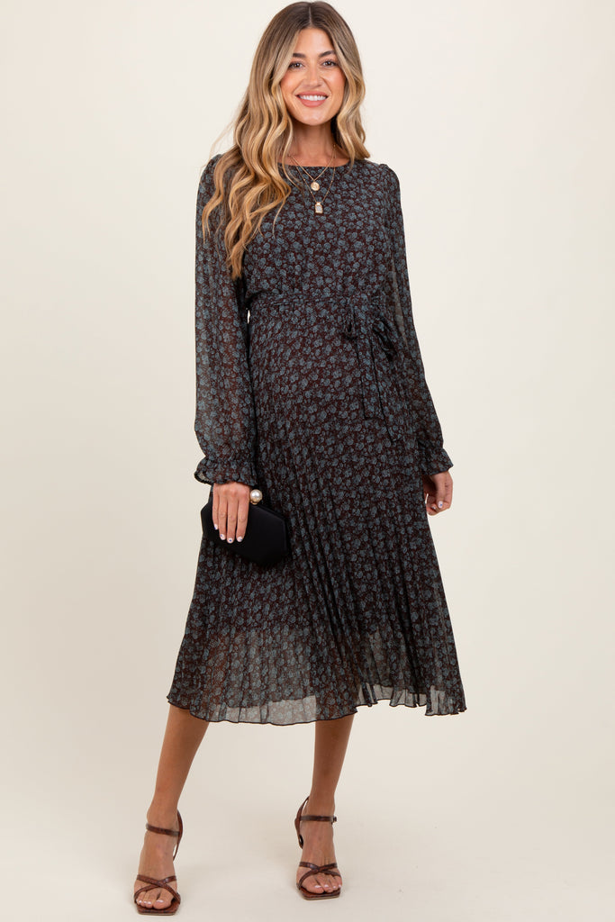 Woman wearing a black floral dress against a white background