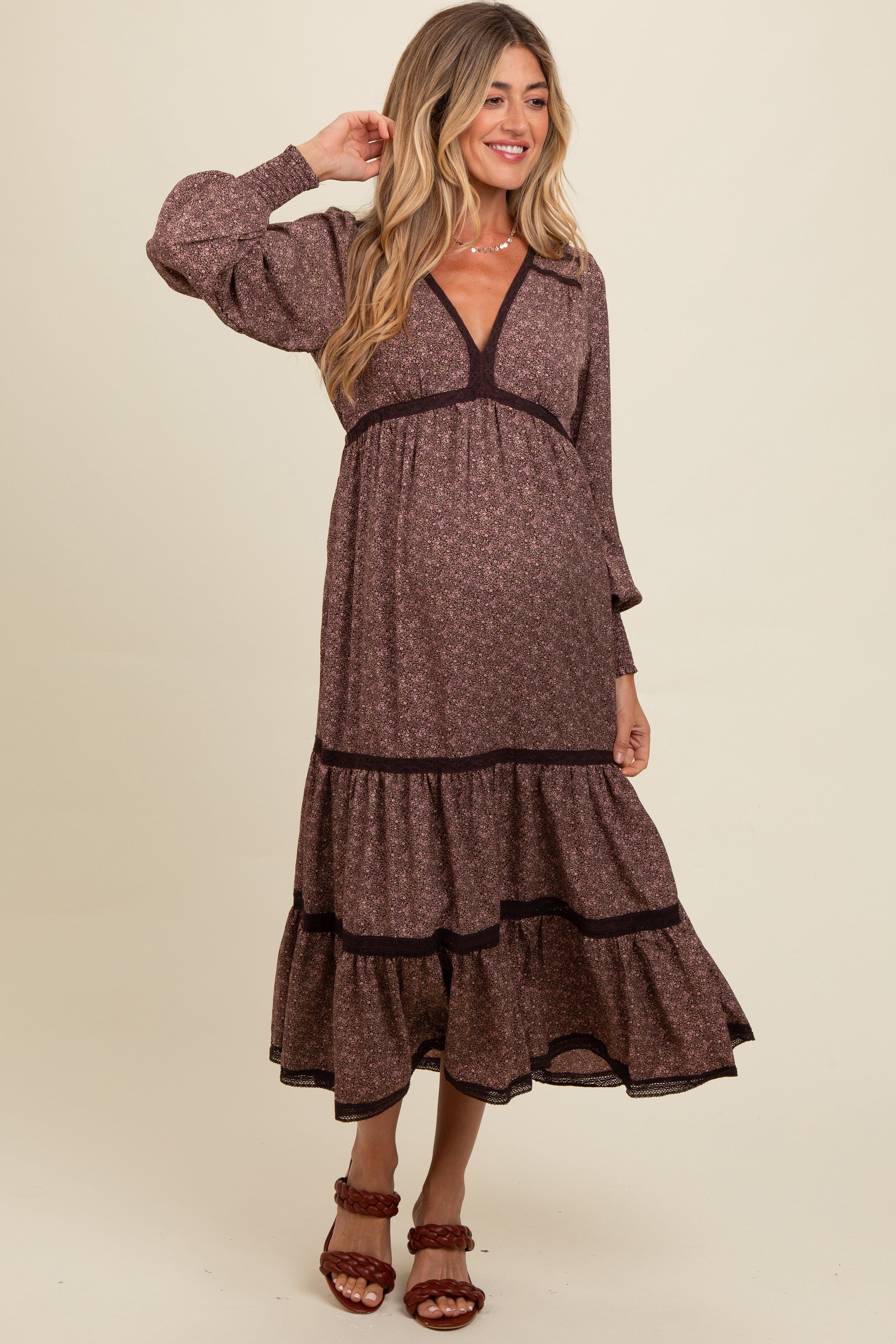 Woman wearing a brown dress with a subtle pattern on a beige background