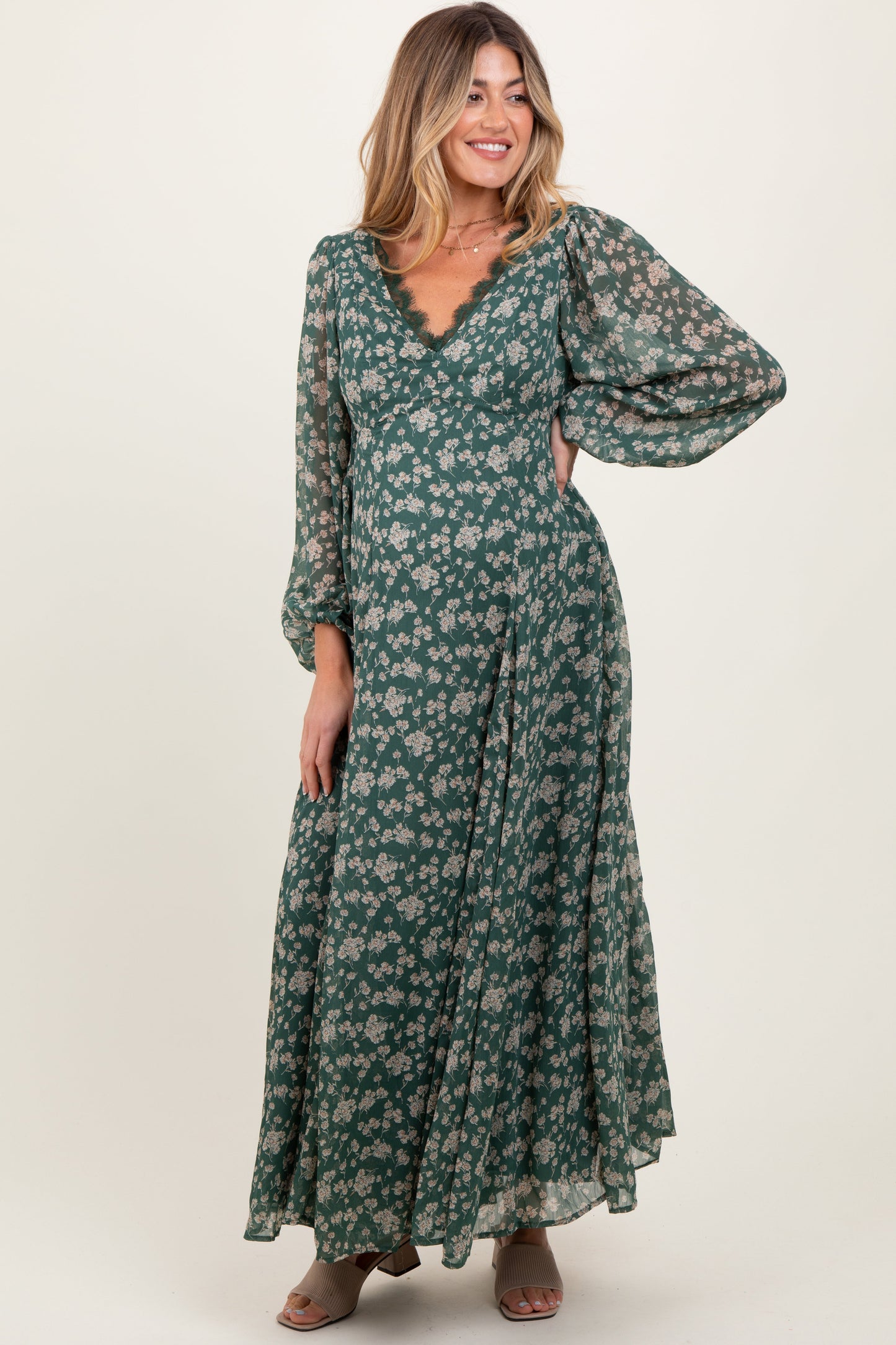 Woman wearing a green floral dress against a white background