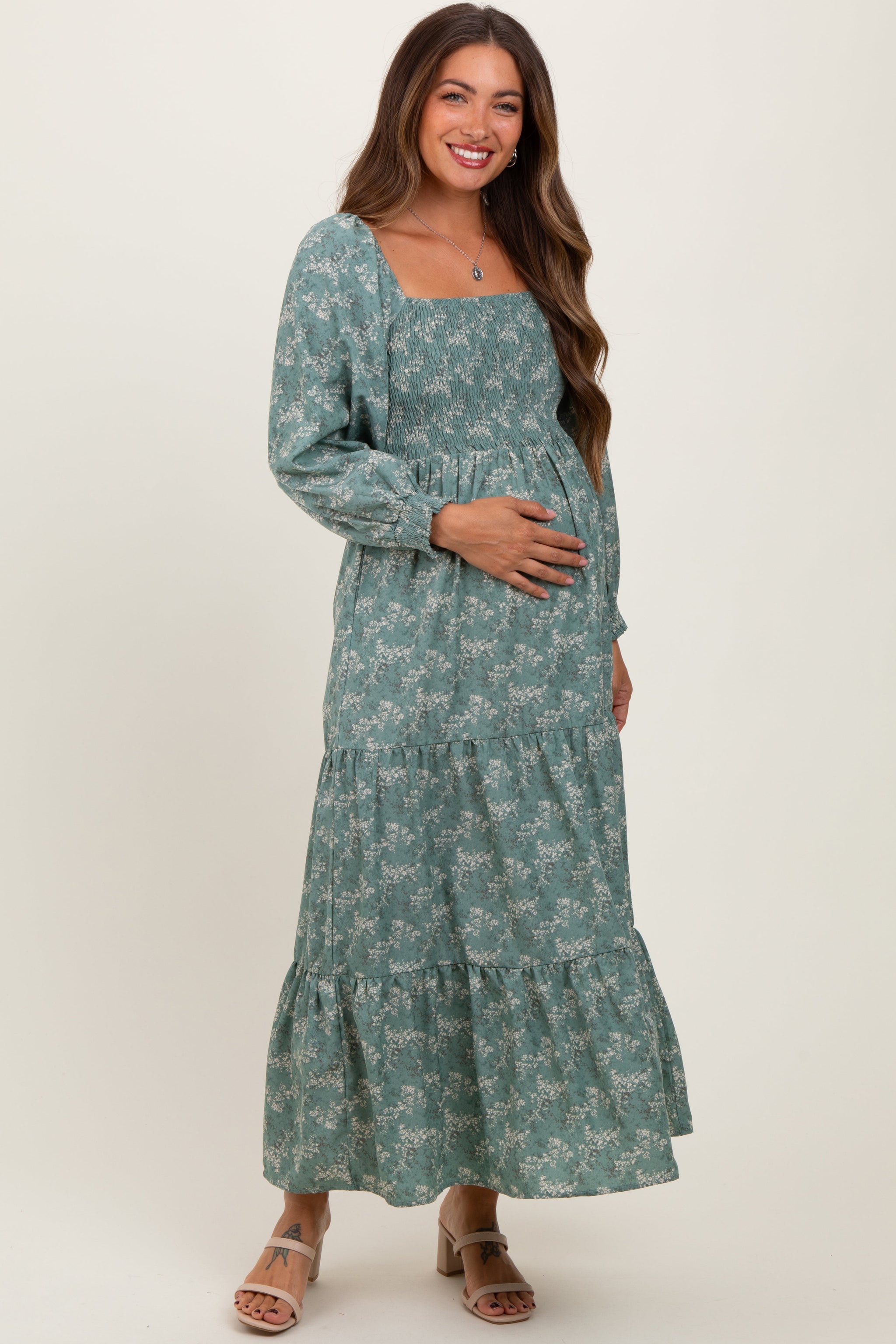 Woman wearing a green floral dress on a white background