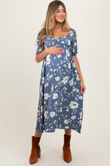 Woman wearing a blue floral dress with brown boots on a white background