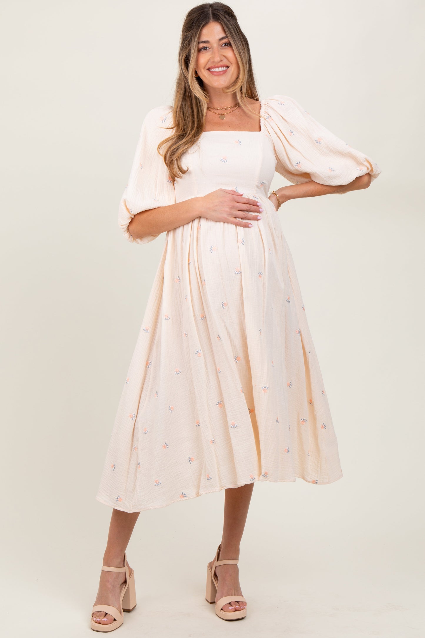 Woman wearing a white dress with a subtle pattern on a plain background