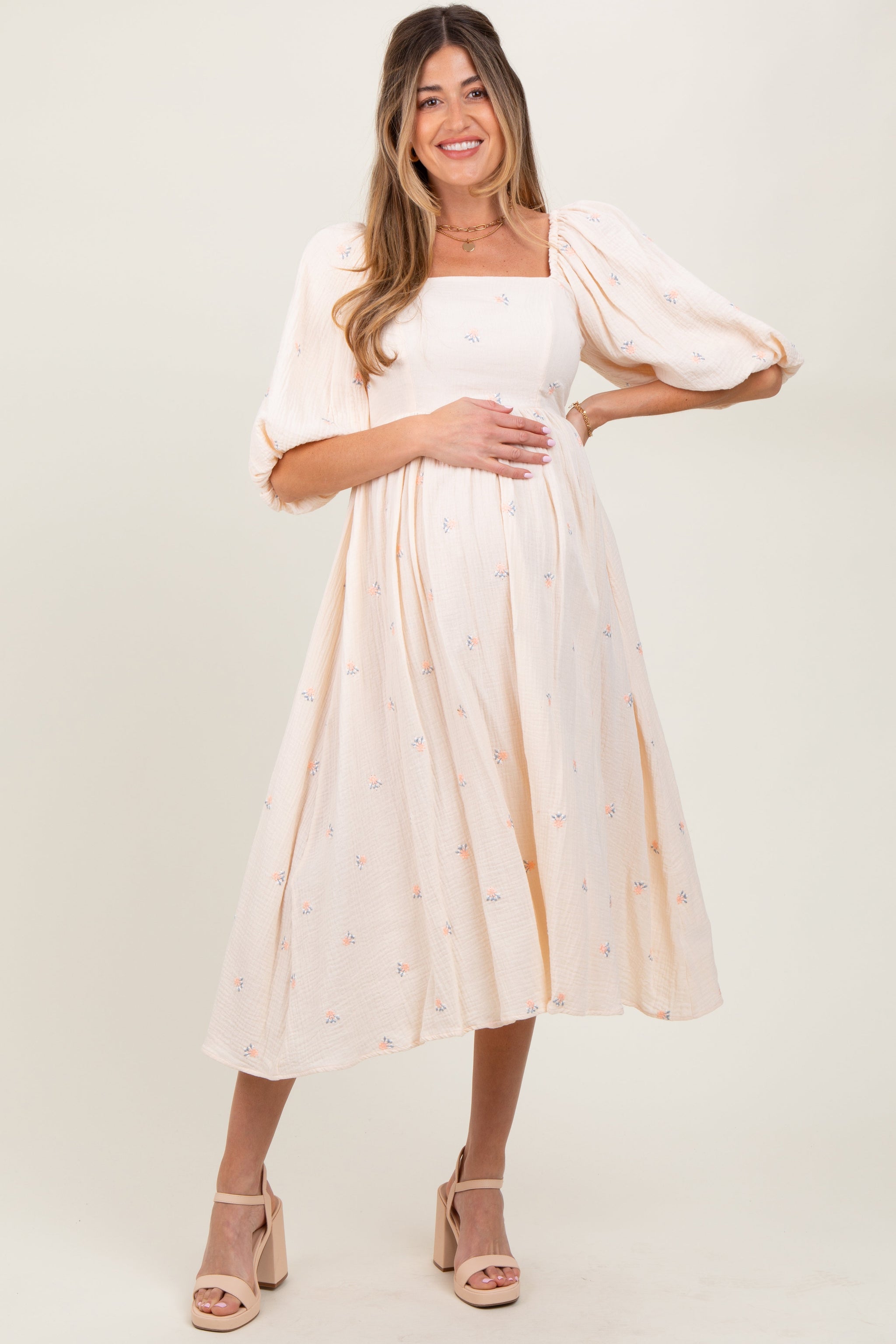 Woman wearing a white dress with a subtle pattern on a plain background