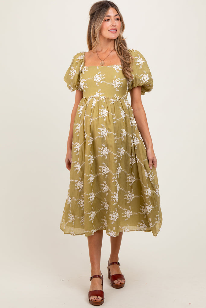 Woman wearing a yellow floral dress on a white background