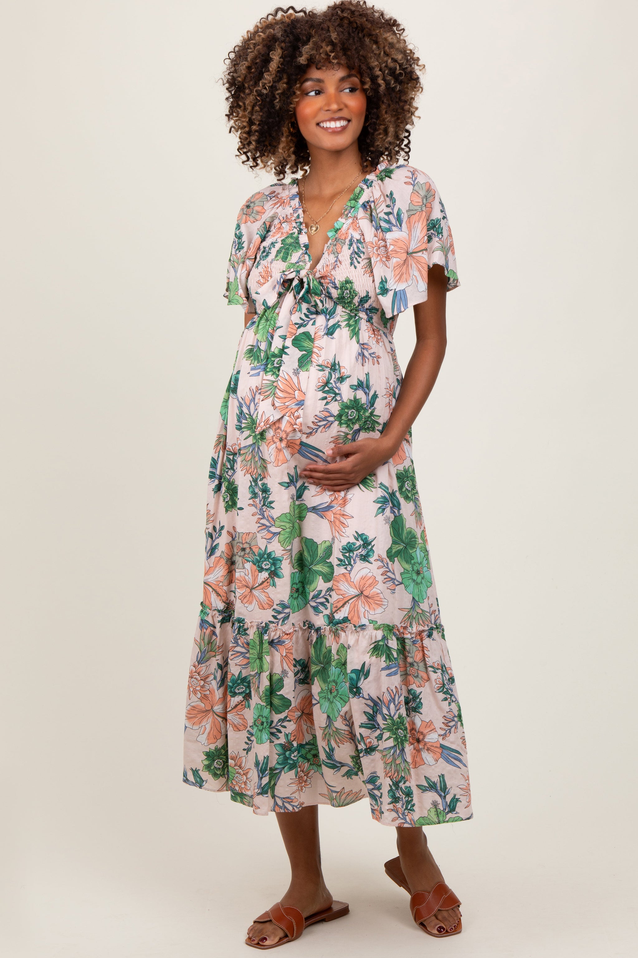 Woman wearing a floral dress against a plain background
