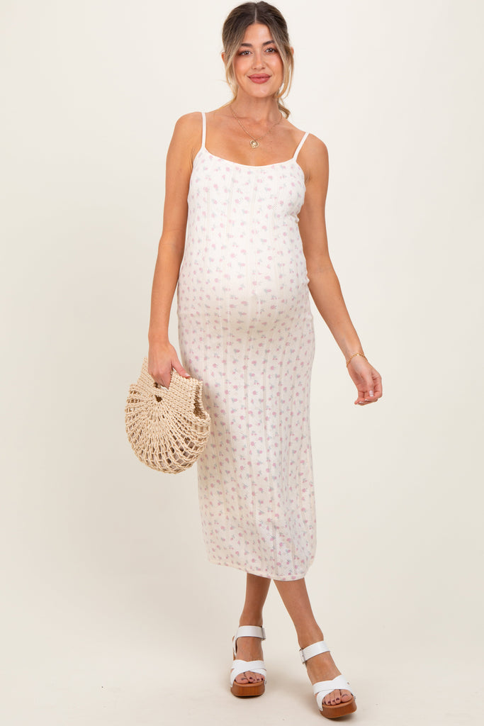 Woman wearing a white patterned dress holding a woven bag on a beige background