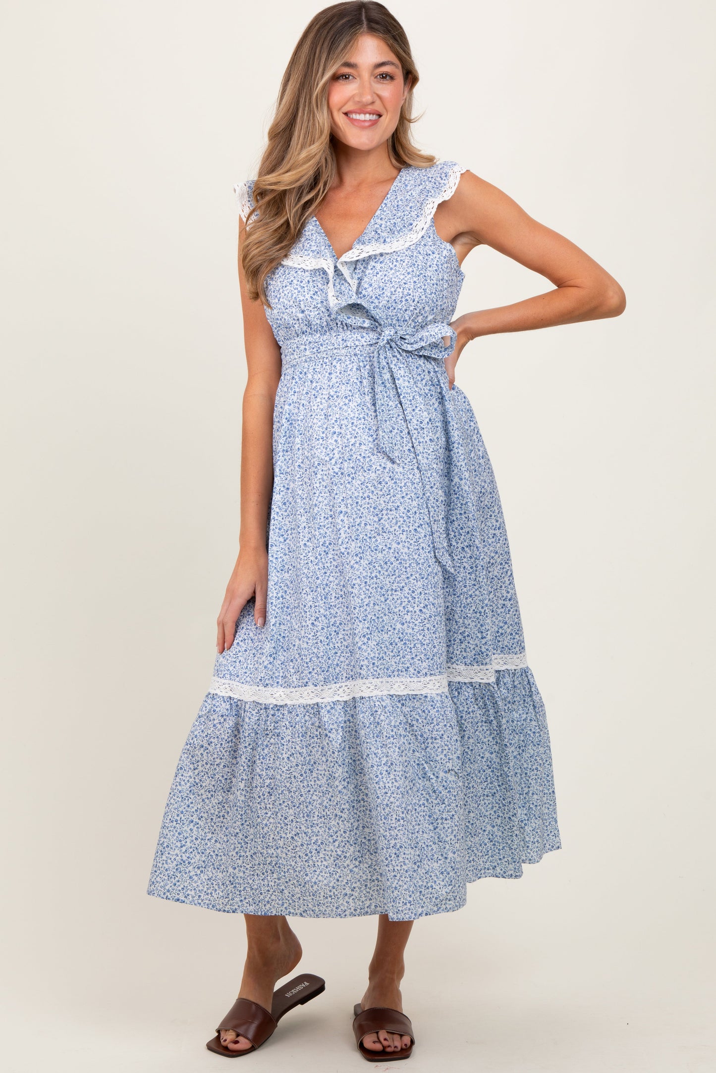 Woman wearing a blue floral dress with a white background