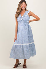 Woman wearing a blue floral dress with a white background