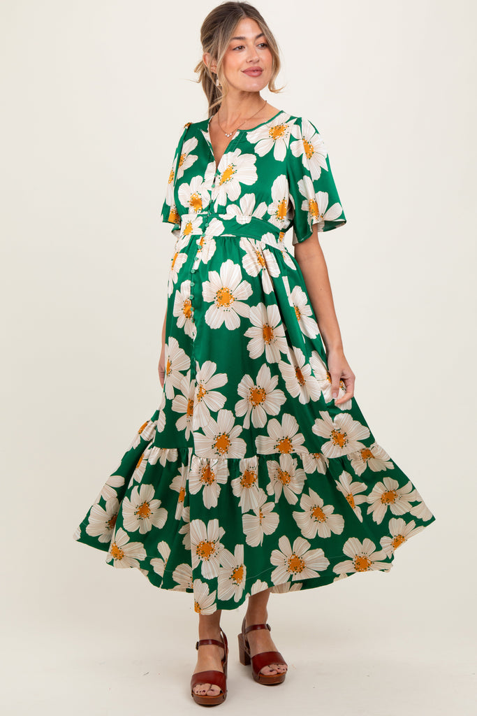 Woman wearing a green dress with white floral pattern on a white background