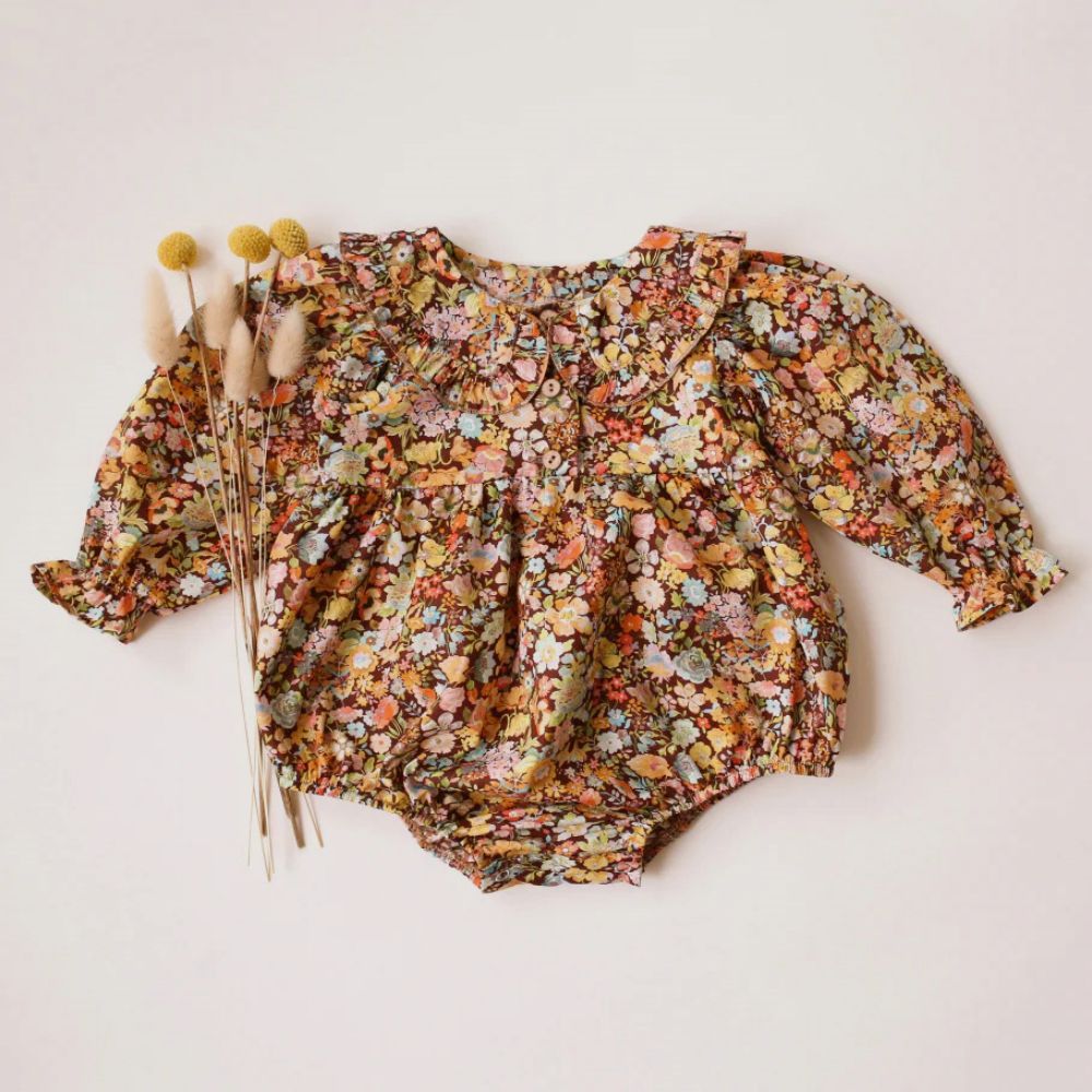 Floral-patterned baby romper on a light background