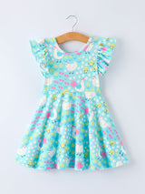 Children's dress with chicken pattern on a hanger against a white background