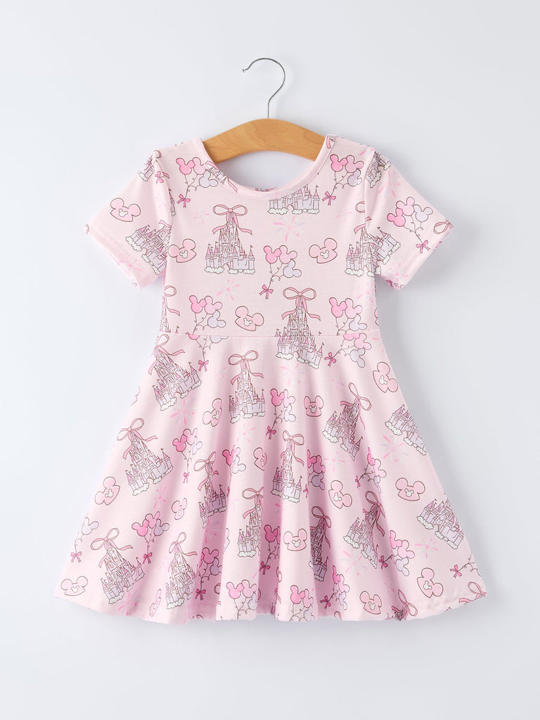 Pink dress with bow and castle pattern on a hanger against a white background