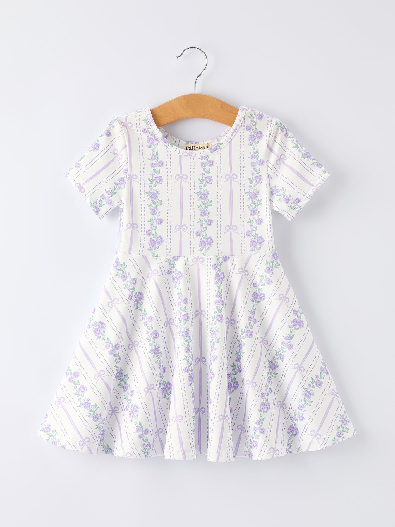 White dress with purple floral pattern on a hanger against a white background