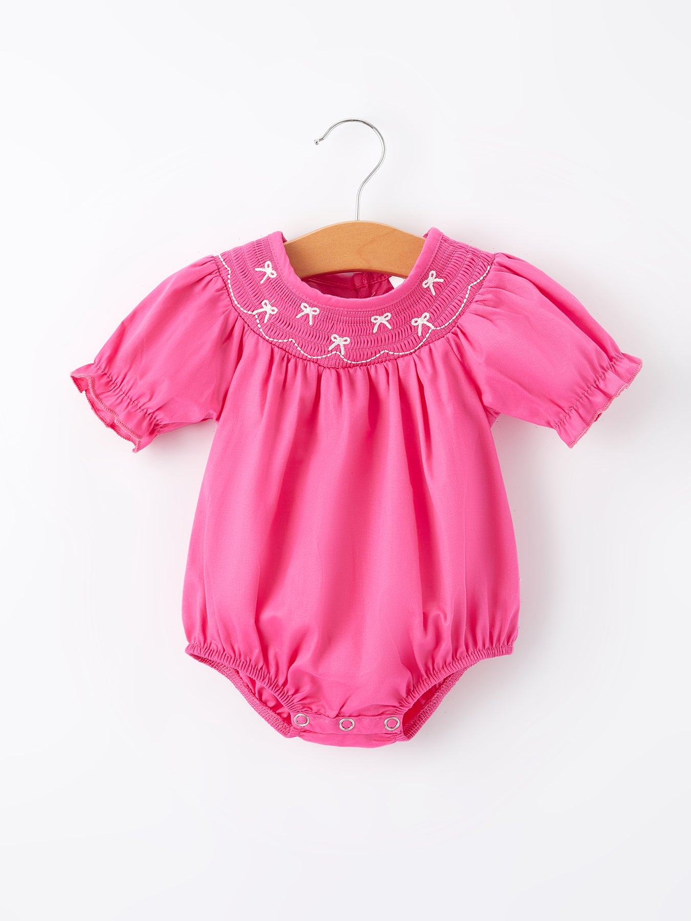 Pink baby romper with embroidered collar on a white background