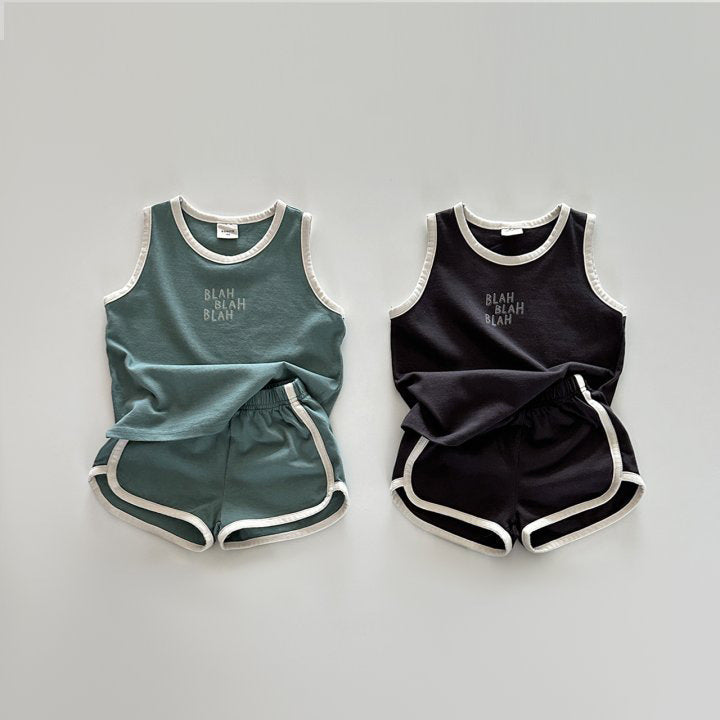 Two children's outfits, one green and one black, on a light gray background.