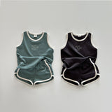 Two children's outfits, one green and one black, on a light gray background.