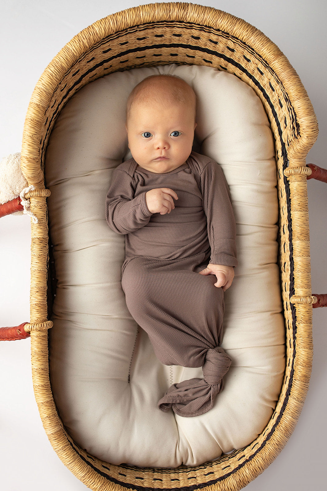 Ultra-soft, stretchy gender neutral baby gowns designed for comfort, featuring tie bottom and pull-down shoulder tabs for convenience. Cocoa Knotted Gown in a Snuggle Me Organics in a Plum + Sparrow Moses Baby BasketUltra-soft, stretchy gender neutral baby gowns designed for comfort, featuring tie bottom and pull-down shoulder tabs for convenience. Cocoa Knotted Gown in a Snuggle Me Organics in a Plum + Sparrow Moses Baby Basket