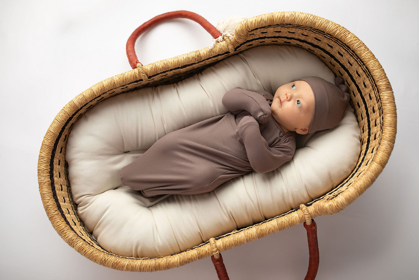 Ultra-soft, stretchy gender neutral baby gowns designed for comfort, featuring tie bottom and pull-down shoulder tabs for convenience. Cocoa Knotted Gown in a Snuggle Me Organics in a Plum + Sparrow Moses Baby Basket