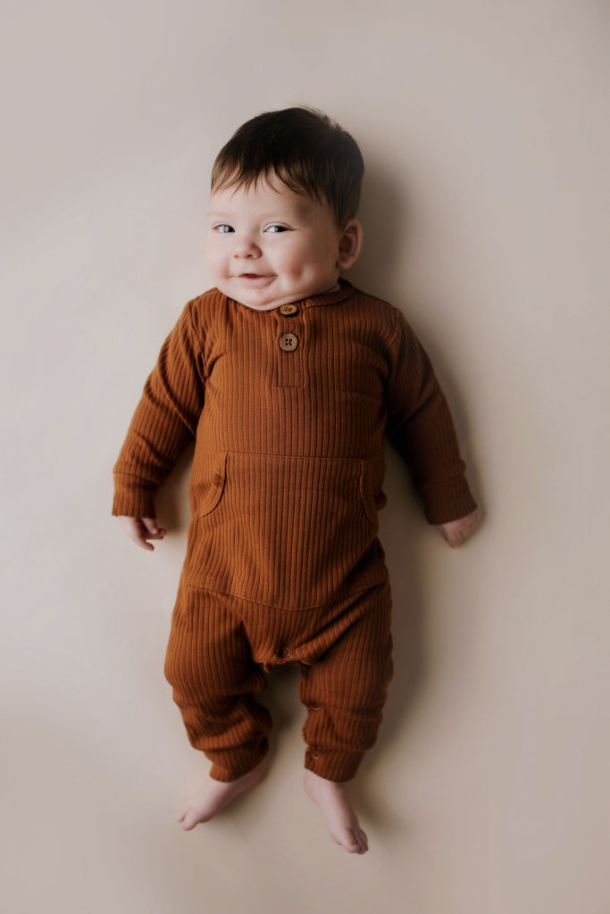 Ribbed long-sleeve onesie with two buttons and leg snaps, crafted from the softest organic cotton blend.