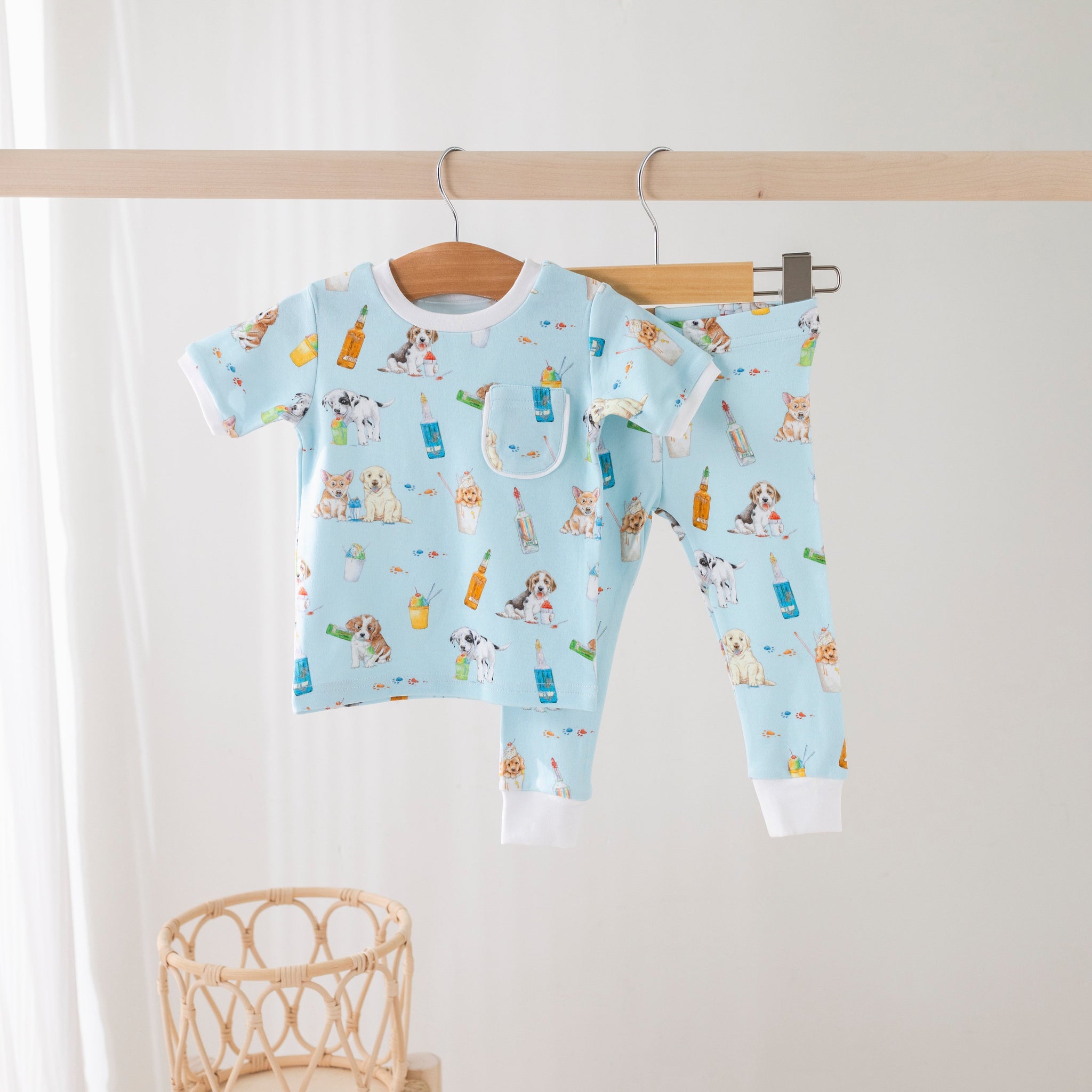Baby outfit with short-sleeve shirt and pants on a hanger against a white background