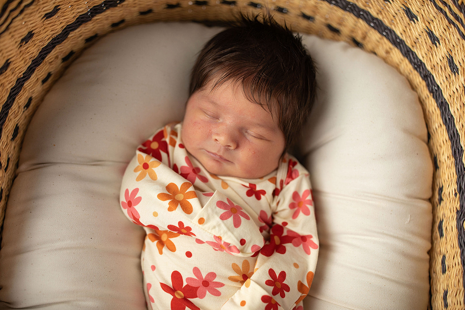 Three Little Tots Flower 70s knotted newborn baby gown is ultra soft and the perfect gift for a newborn baby. Shown in a Snuggle Me Organic in a Plum + Sparrow Moses Basket