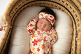 Three Little Tots Flower 70s knotted newborn baby gown is ultra soft and the perfect gift for a newborn baby. Shown in a Snuggle Me Organic in a Plum + Sparrow Moses Basket