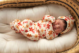 Three Little Tots Flower 70s knotted newborn baby gown is ultra soft and the perfect gift for a newborn baby. Shown in a Snuggle Me Organic in a Plum + Sparrow Moses Basket