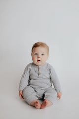 Baby boy in a Three Little Tots playsuit outfit made with organic cotton