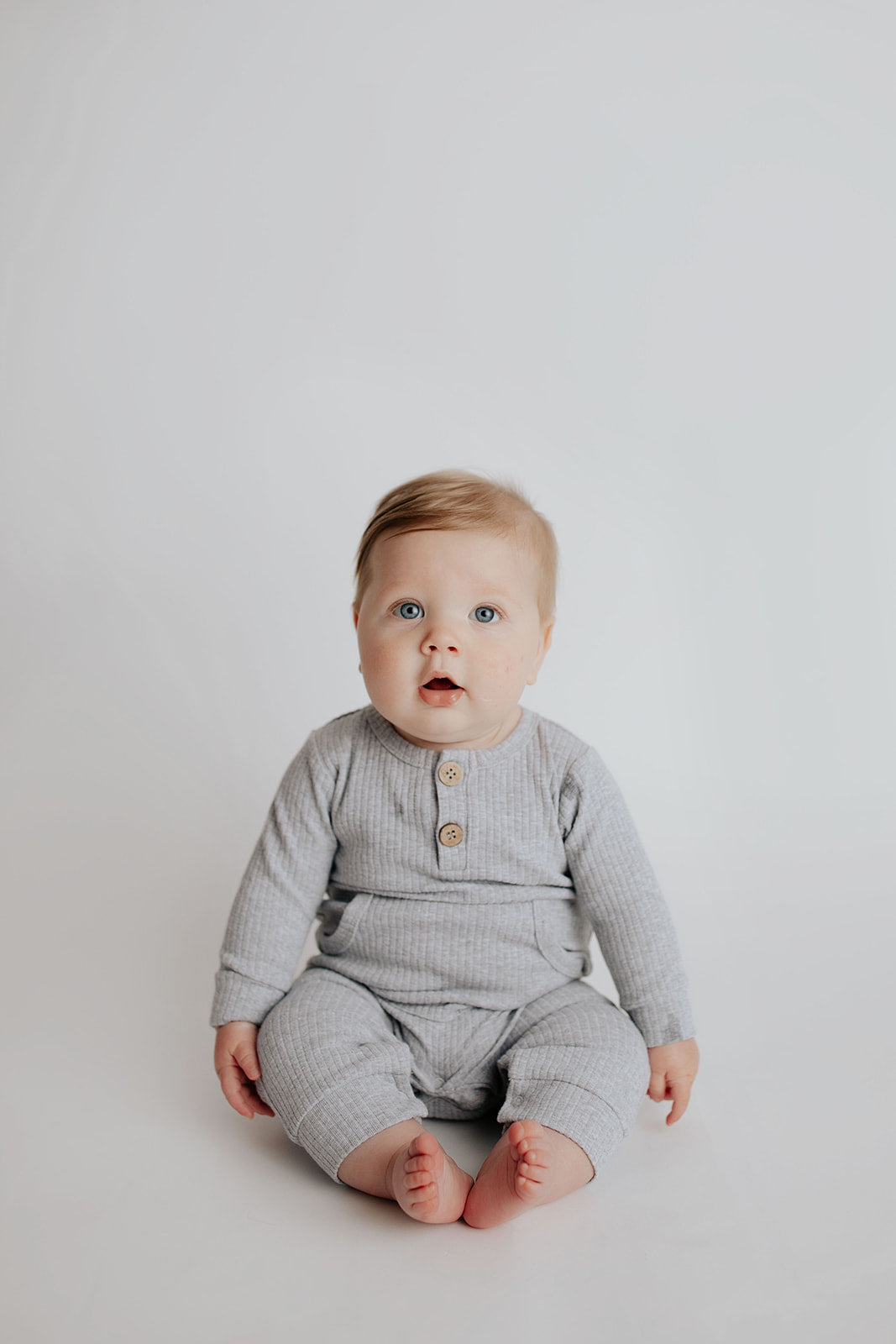 Baby boy in a Three Little Tots playsuit outfit made with organic cotton