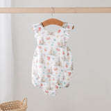 Baby romper with colorful pattern on a wooden hanger against a white background