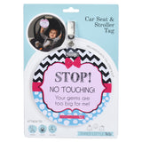 A newborn baby girl in a Nuna car seat with a Three Little Tots No Touching Car Seat Sign