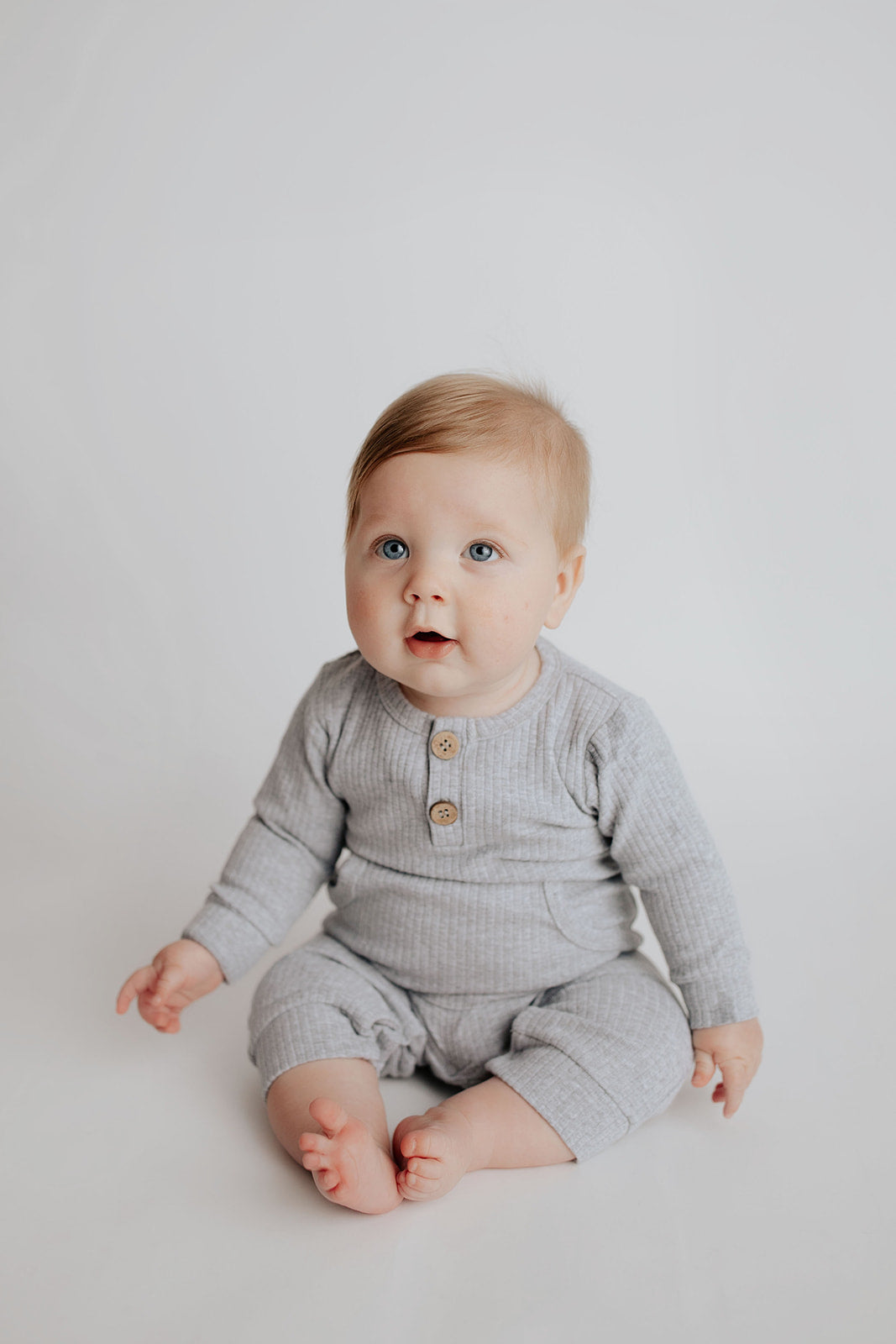 Baby boy in a Three Little Tots playsuit outfit made with organic cotton