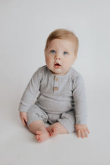 Baby boy in a Three Little Tots playsuit outfit made with organic cotton