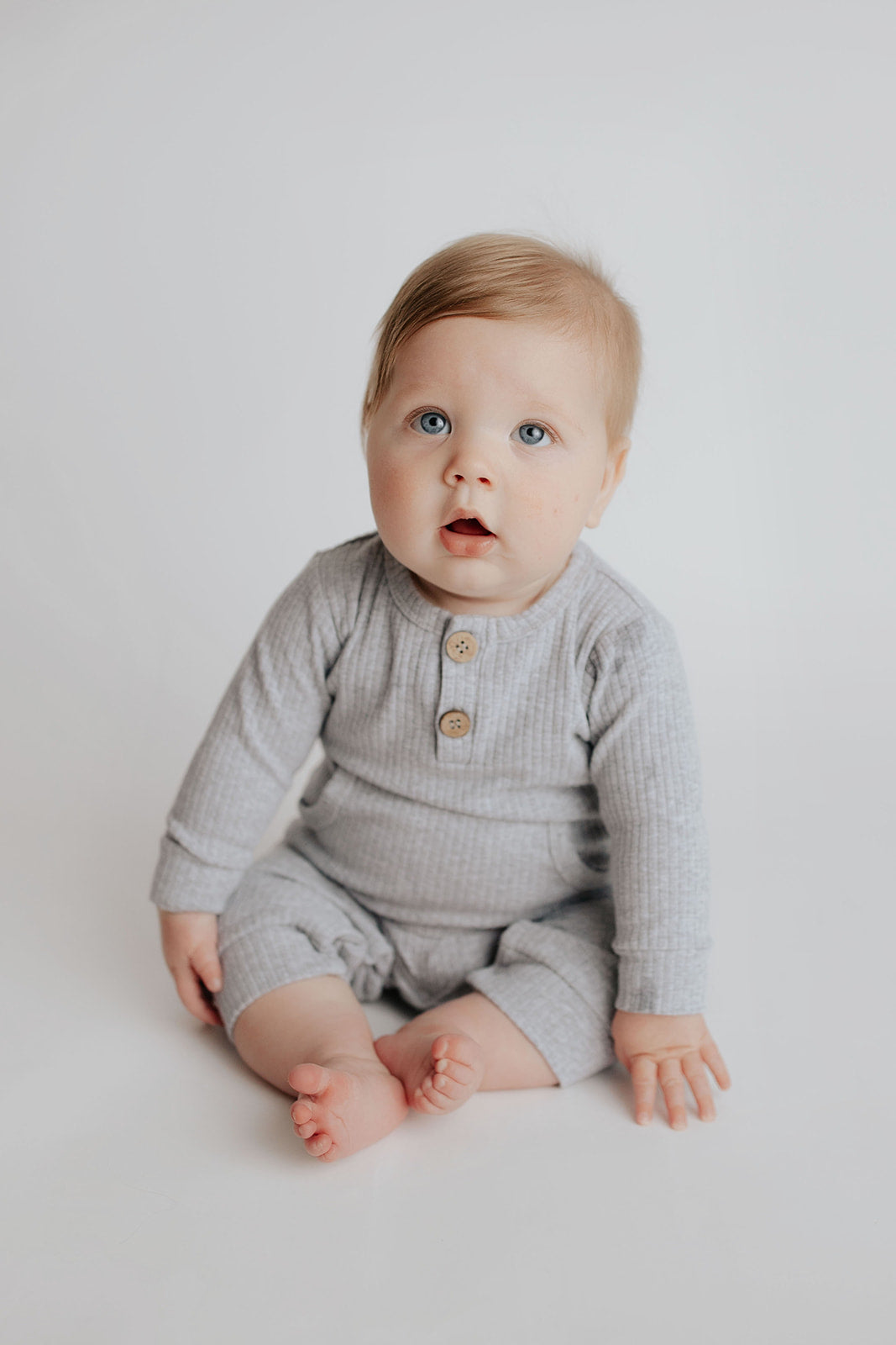 Baby boy in a Three Little Tots playsuit outfit made with organic cotton