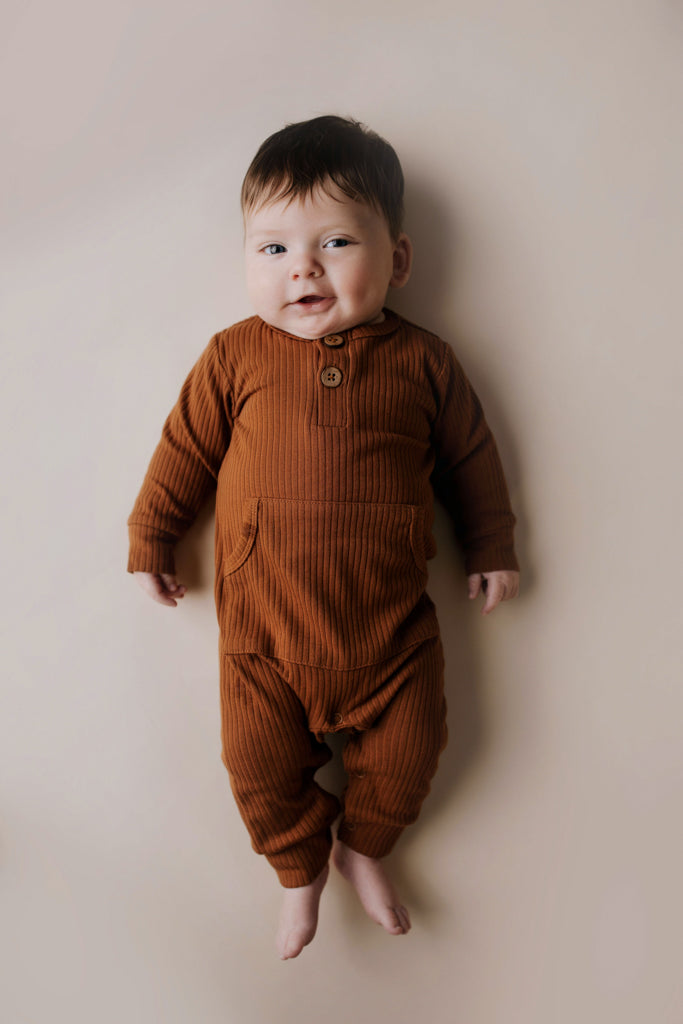 Ribbed long-sleeve onesie with two buttons and leg snaps, crafted from the softest organic cotton blend.