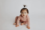 Luxuriously soft ribbed long-sleeve onesie with leg snaps, perfect for lounging and exploring in organic cotton.