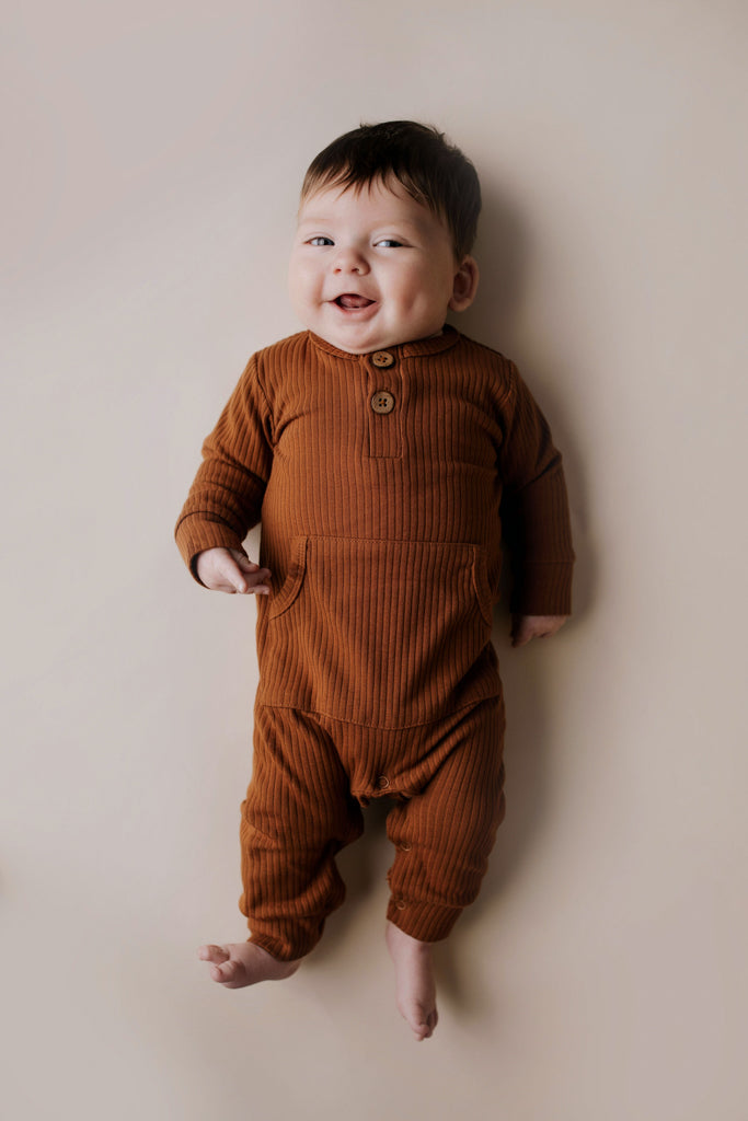 Ribbed long-sleeve onesie with two buttons and leg snaps, crafted from the softest organic cotton blend.