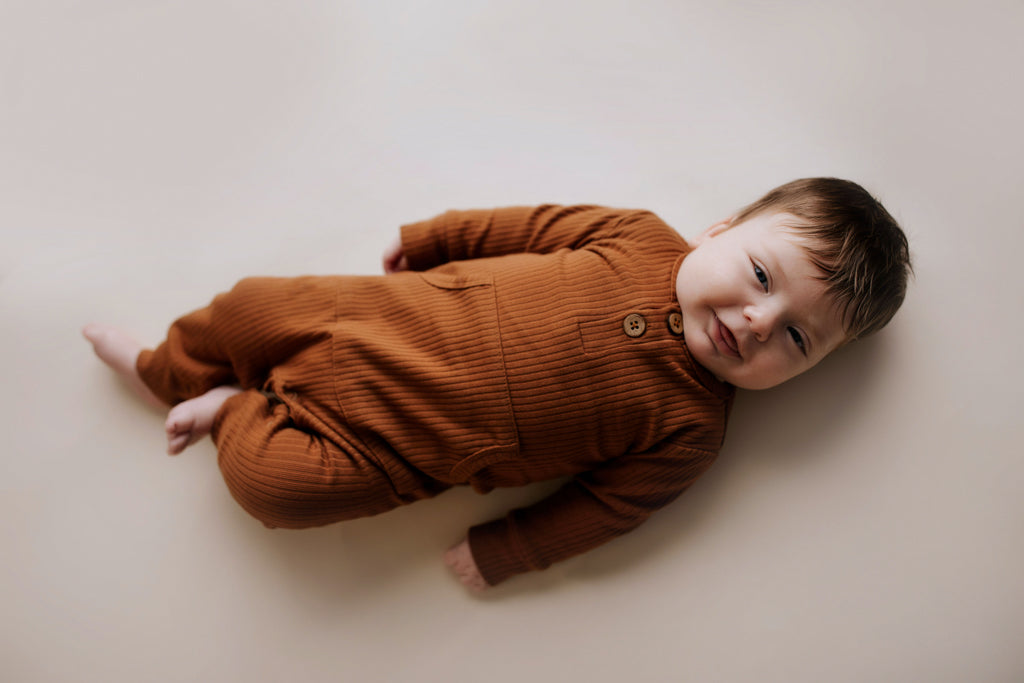 Ribbed long-sleeve onesie with two buttons and leg snaps, crafted from the softest organic cotton blend.