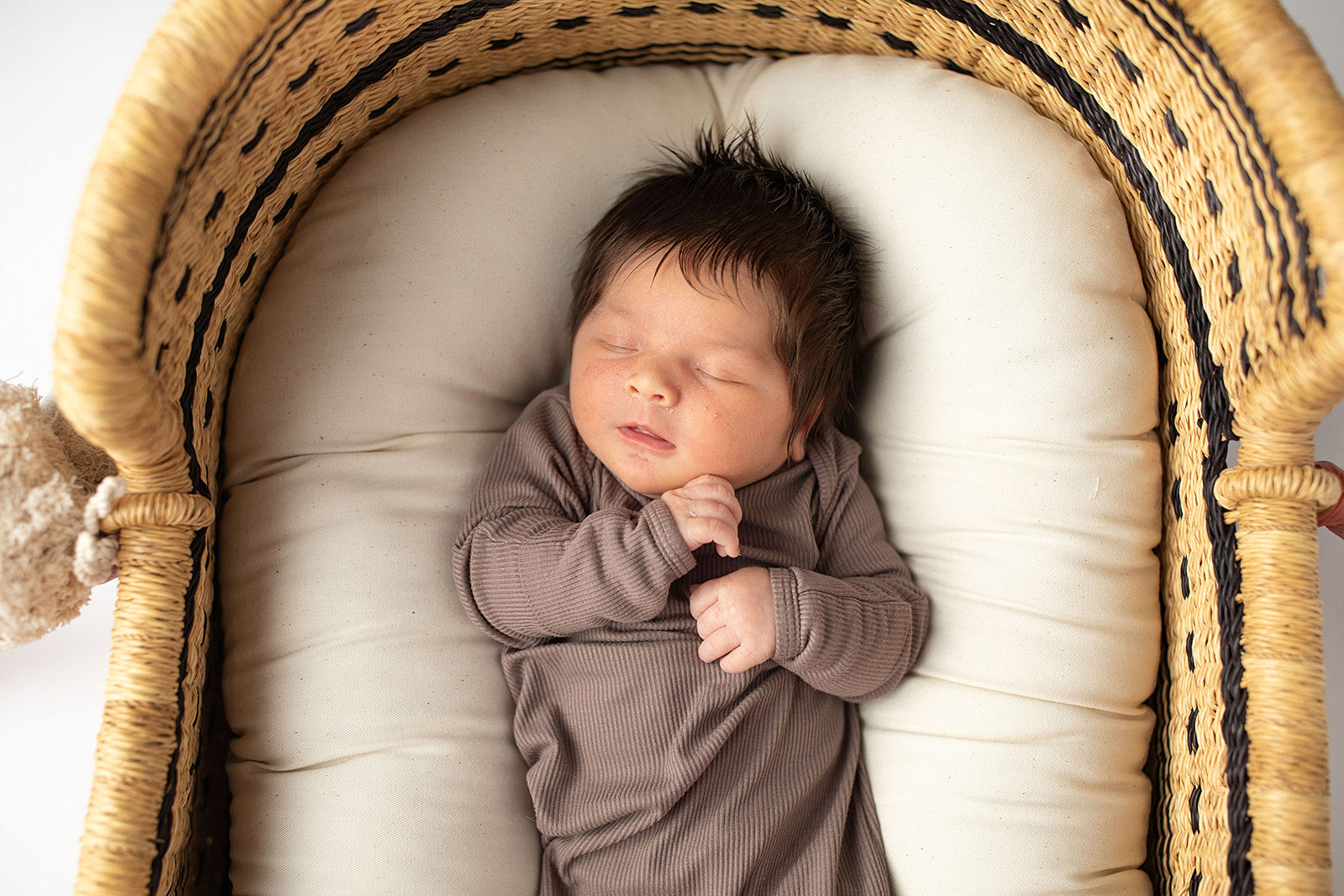 Ultra-soft, stretchy gender neutral baby gowns designed for comfort, featuring tie bottom and pull-down shoulder tabs for convenience. Cocoa Knotted Gown in a Snuggle Me Organics in a Plum + Sparrow Moses Baby Basket