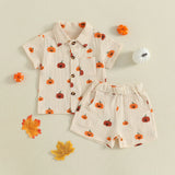 Children's outfit with pumpkin pattern shirt and shorts on a beige background