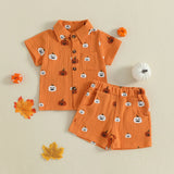 Children's orange outfit with pumpkin pattern on a beige background