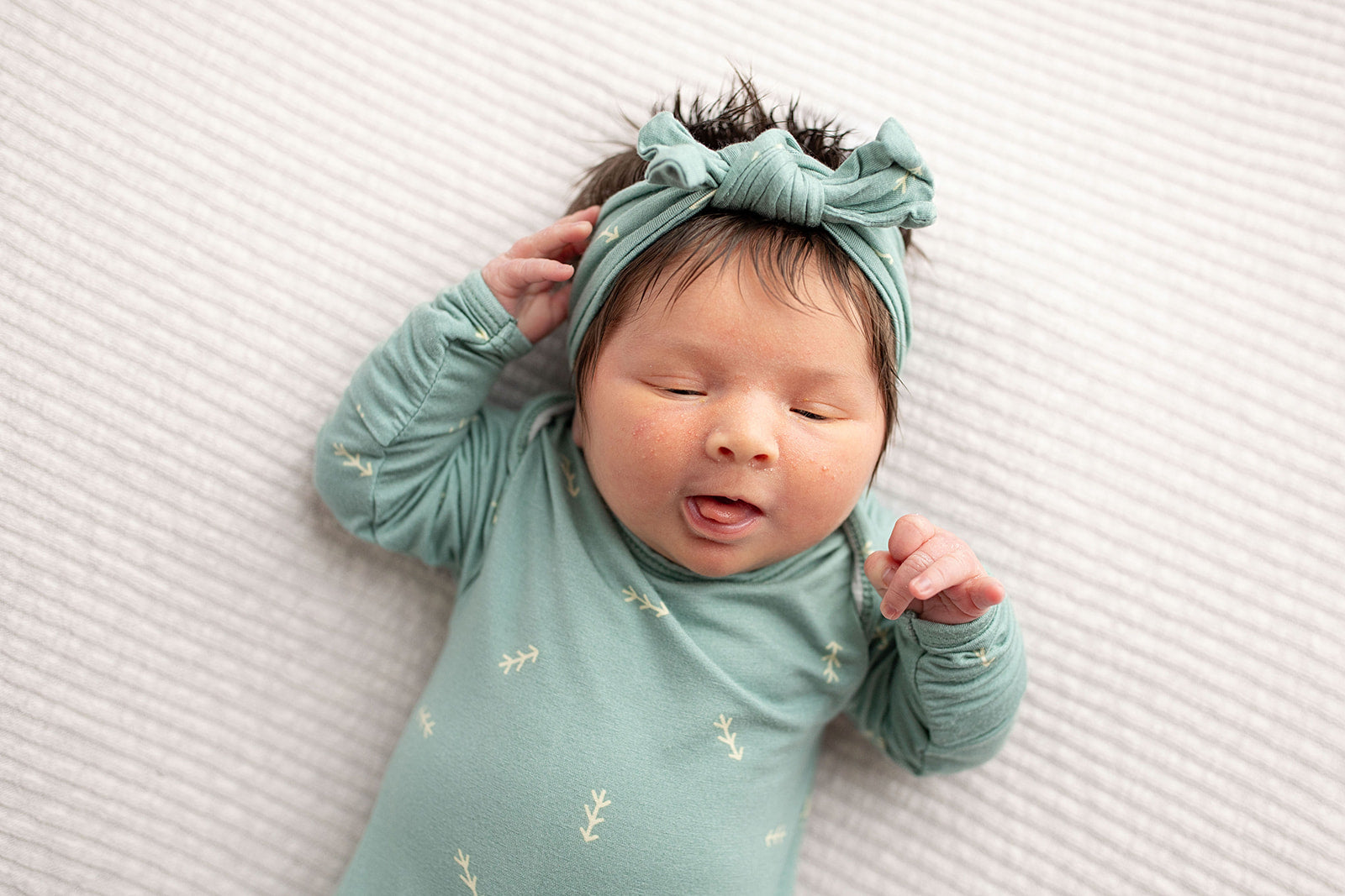 Three Little Tots Arrow Newborn Knotted Baby Gown. Ultra Soft baby gown. Little newborn baby girl with a headband and lots of hair.