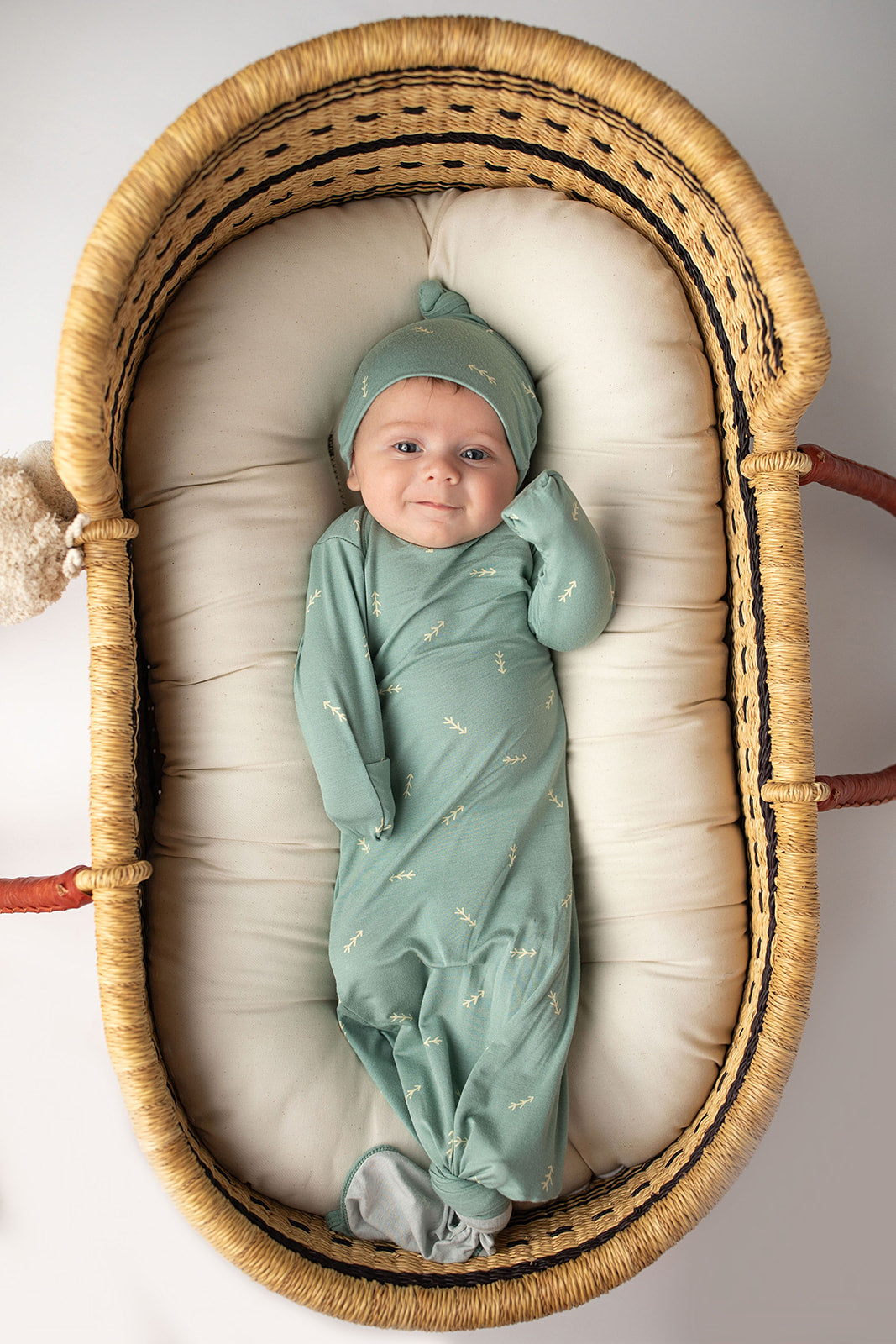 Three Little Tots Arrow Newborn Knotted Baby Gown. Newborn baby in Snuggle Me Organics in a Plum and Sparrow Moses Basket
