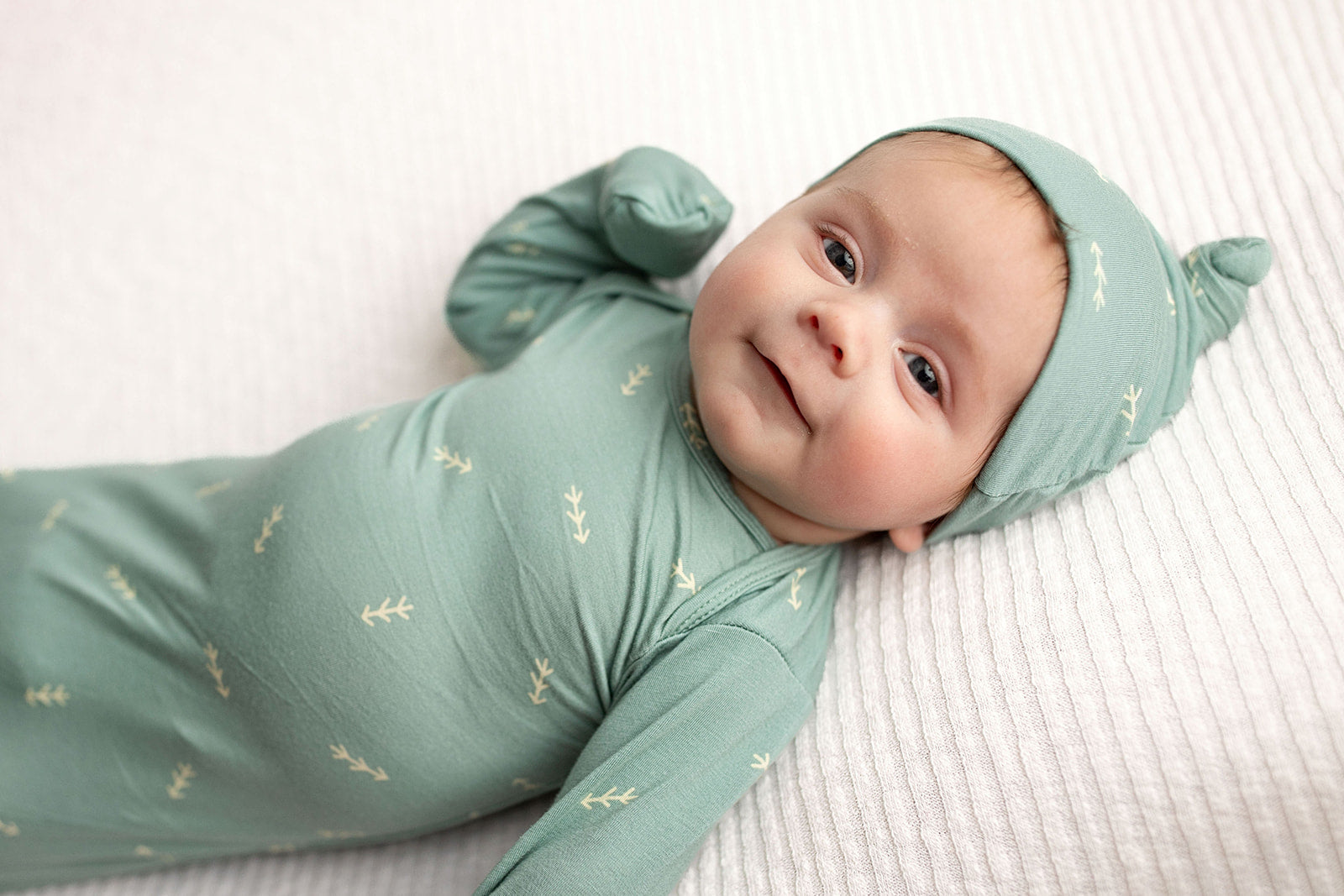 Three Little Tots Arrow Newborn Knotted Baby Gown with hat. Little newborn baby boy shown with Three Little Tots knotted baby gown with fold over mittens