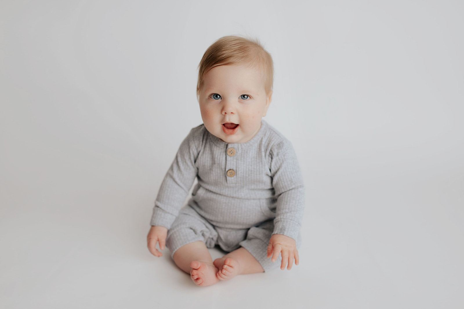 Baby boy in a Three Little Tots playsuit outfit made with organic cotton