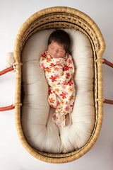 Three Little Tots Flower 70s knotted newborn baby gown is ultra soft and the perfect gift for a newborn baby. Shown in a Snuggle Me Organic in a Plum + Sparrow Moses Basket