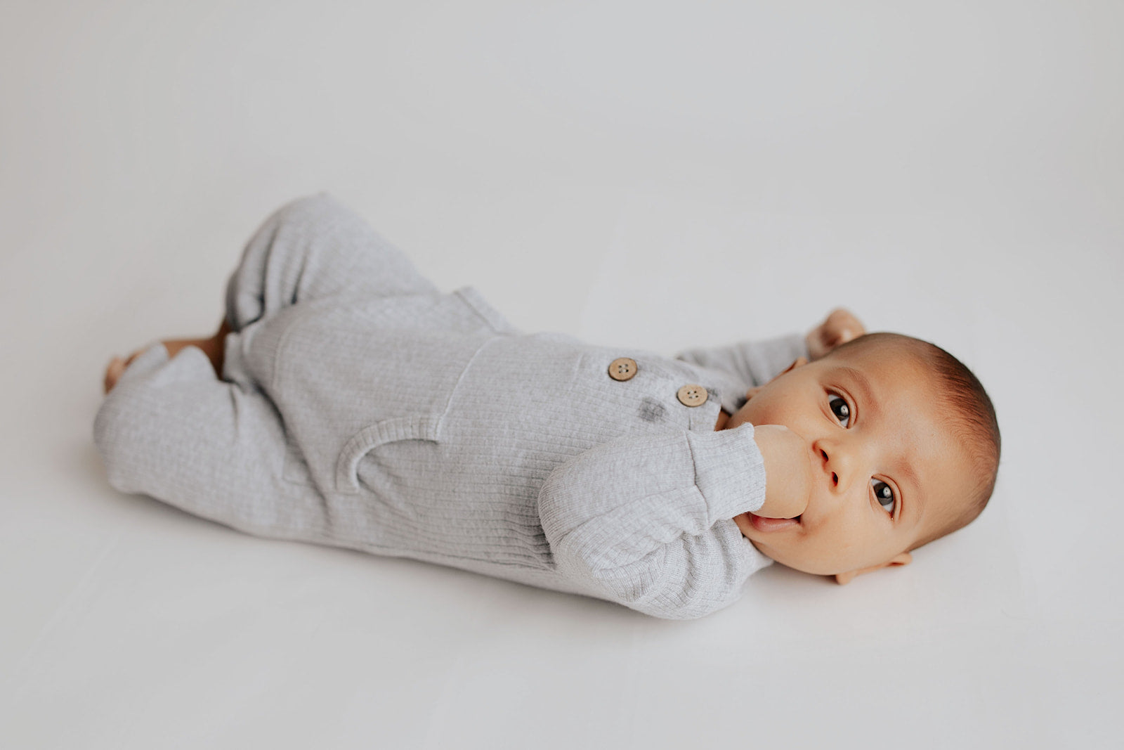 Baby boy in a Three Little Tots playsuit outfit made with organic cotton