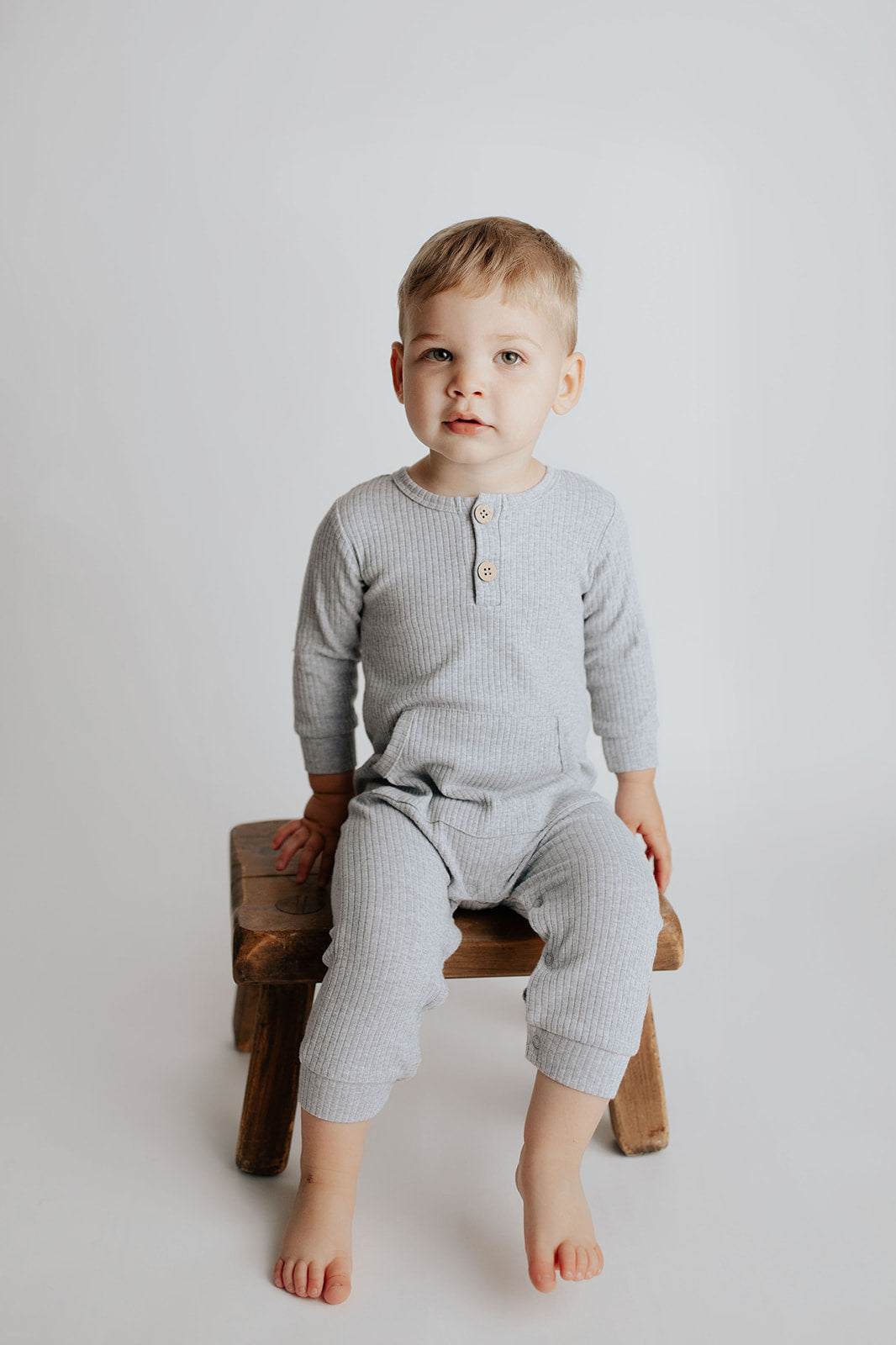Baby boy in a Three Little Tots playsuit outfit made with organic cotton