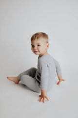 little boy in a Three Little Tots playsuit outfit made with organic cotton